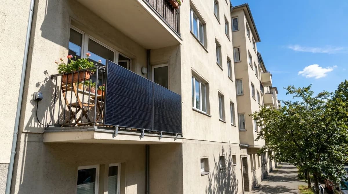 Balkonkraftwerk: zwei Solarmodule am Balkongeländer eines Mehrfamilienhauses